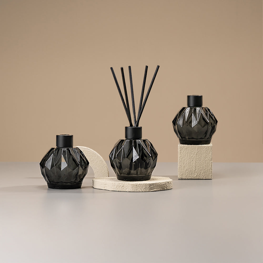 A diffuser with a soft, subtle design, surrounded by eucalyptus plants, conveying a fresh and natural ambiance, placed on a light neutral surface.
