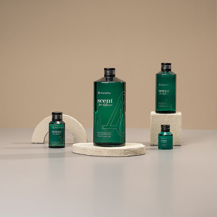 A selection of diffusers with different bottle shapes and elegant designs, arranged on a light grey surface with a neutral, beige backdrop.